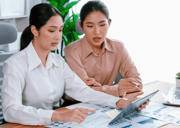 Two linguists check balances and dates on bank statements for Chinese Translation Services in Texas in a certified review.