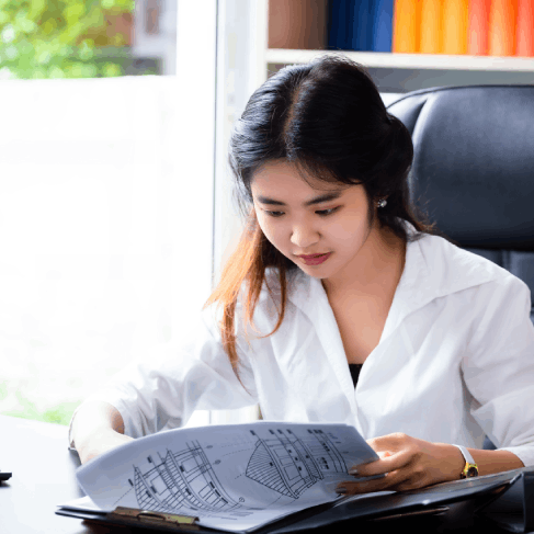 An engineer compares a Vietnamese manual to an English schematic using Vietnamese Translation Services in Texas.